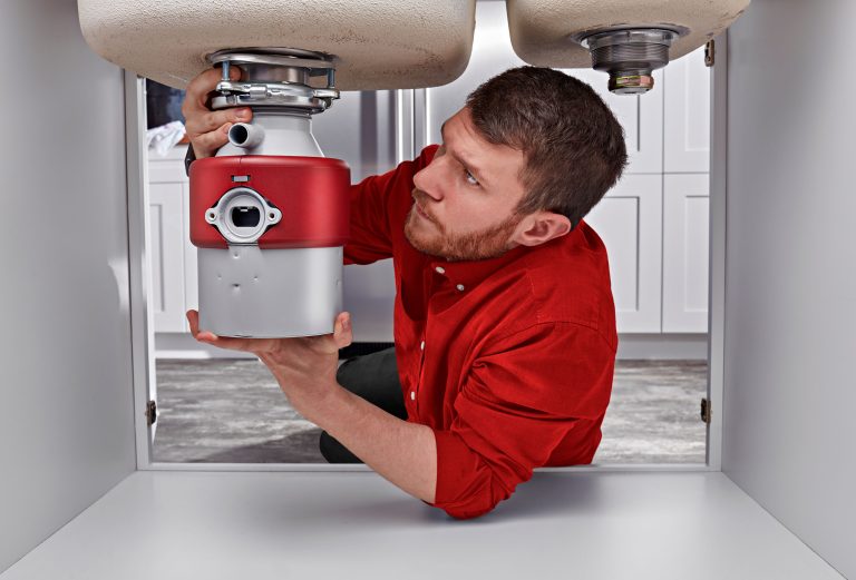 Warners' Stellian plumber installing a garbage disposal