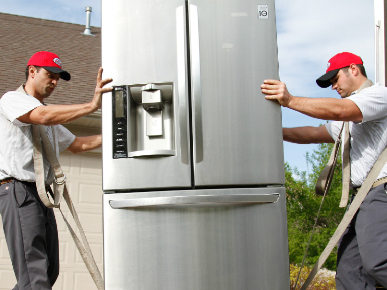 Delivery crew carrying refrigerator.